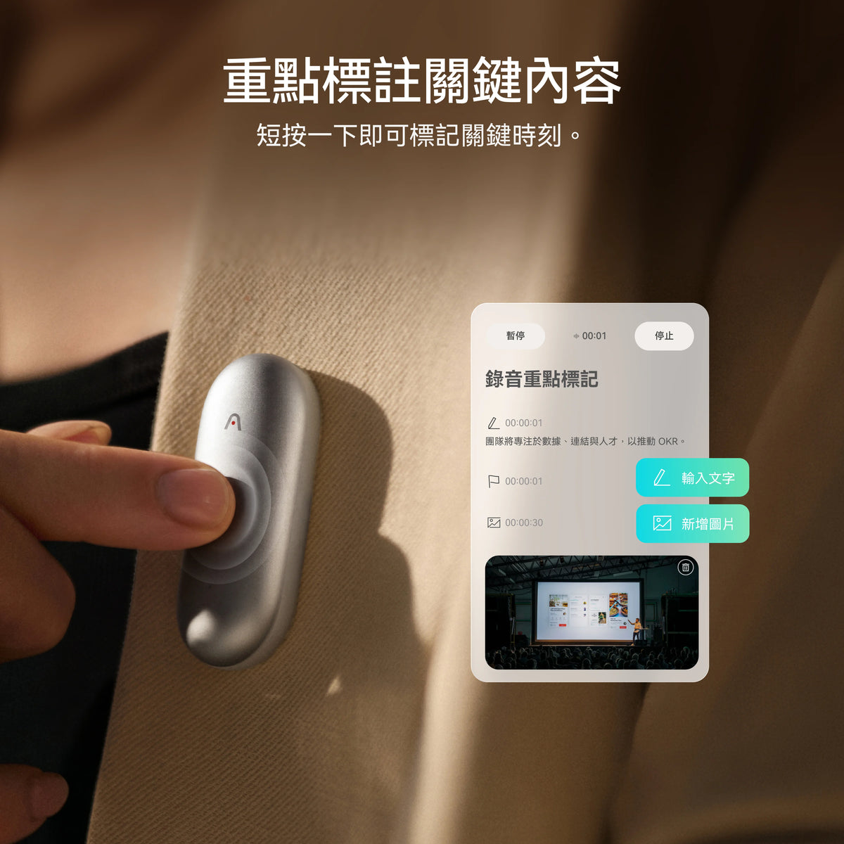 手指按下別在西裝上的銀色 Plaud NotePin S 圓形按鈕，短按即可標記錄音重點。